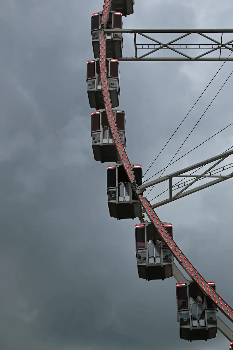 Ferris wheel cabins ascending against a stormy gray sky symbolizing emotional ups and downs uncertainty and resilience in trauma therapy annapolis