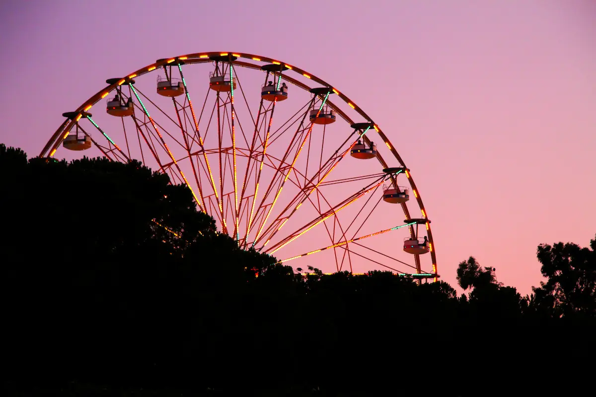 Ferris wheel glowing at dusk against a soft pink evening sky symbolizing perspective lifes changing cycles reflection and finding moments of joy and balance through emotional healing and therapy