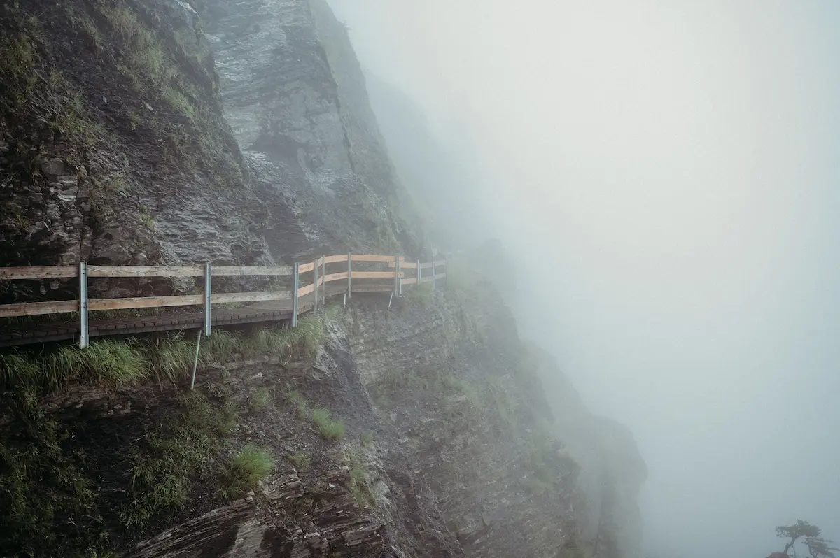 Foggy cliffside walkway along steep rocks symbolizing uncertainty courage emotional resilience and trusting the path ahead