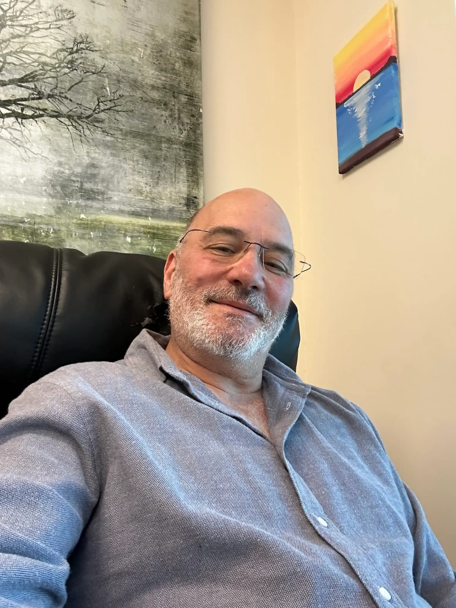 Dr adam klein with glasses and white beard seated in an office chair