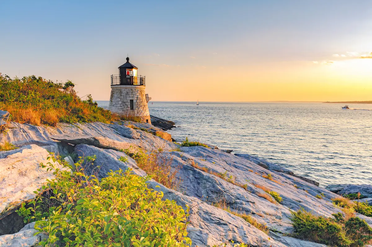 Lighthouse on a rocky shoreline at sunset symbolizing guidance in depth oriented therapy annapolis