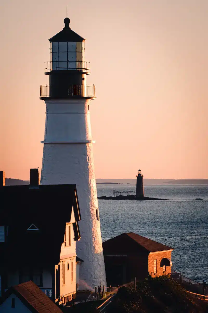 Lighthouse overlooking calm coastal waters at sunset symbolizing guidance and hope in trauma therapy annapolis