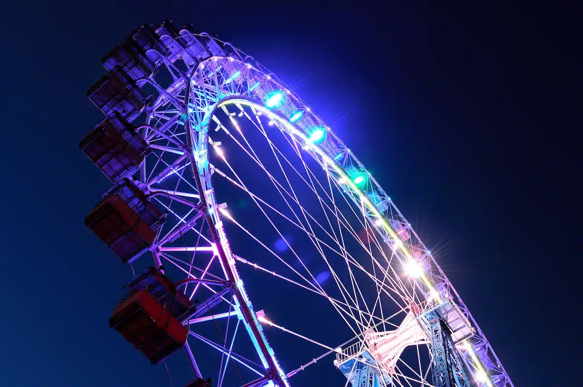 Neon lit ferris wheel against a night sky reflecting life transitions in depth oriented therapy annapolis