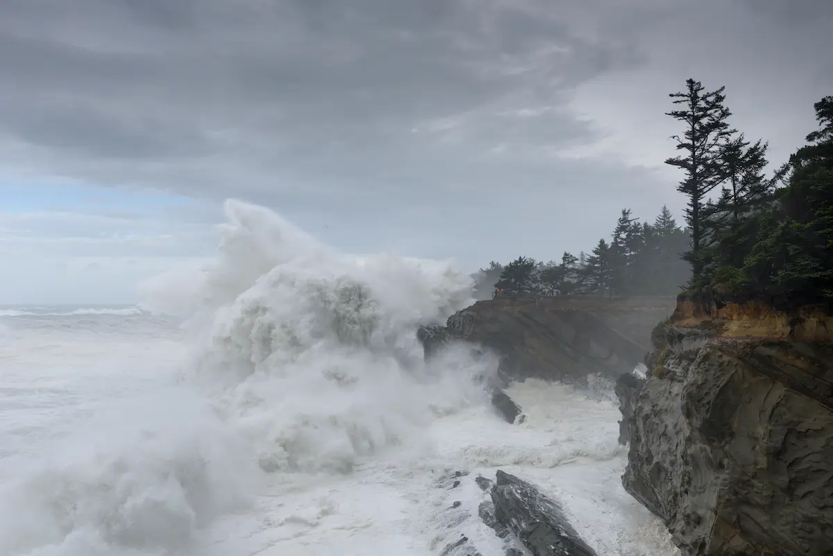 Powerful waves crashing against rocky cliffs beneath storm clouds reflecting emotional intensity in trauma therapy annapolis