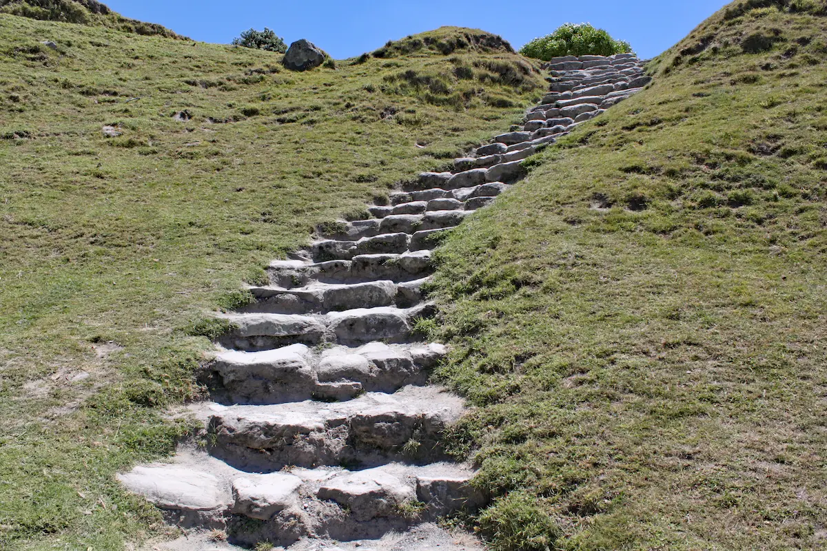 Stone steps leading uphill through grassy hills symbolizing personal growth resilience and progress made one step at a time