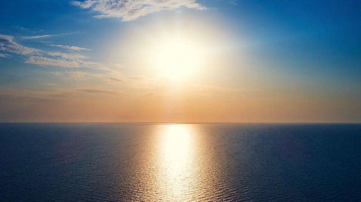 Sun glowing over a calm ocean horizon with soft reflections across the water representing peace clarity and emotional healing in trauma therapy annapolis