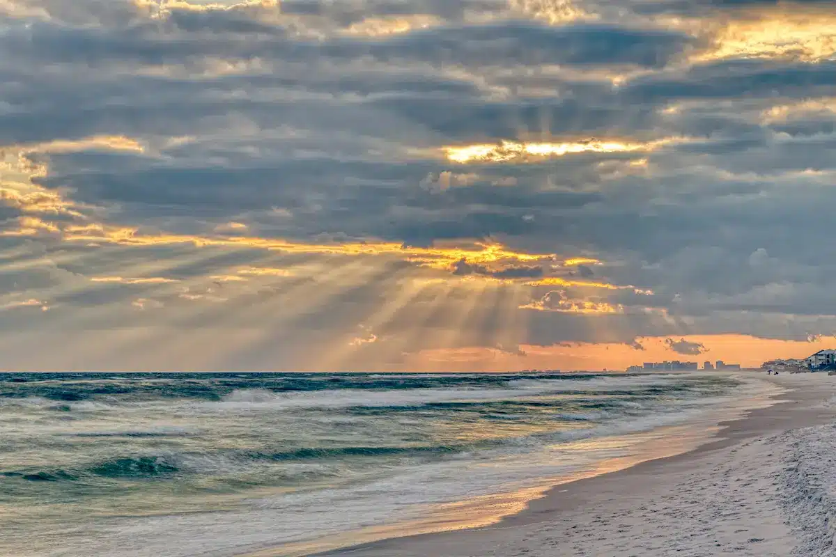 Sunbeams breaking through storm clouds over the ocean evoking hope in depth oriented therapy annapolis