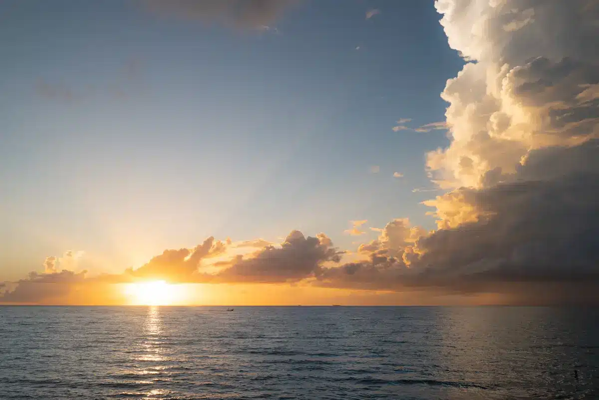 Sunrise over calm ocean beside towering storm clouds reflecting hope and emotional depth in therapy annapolis