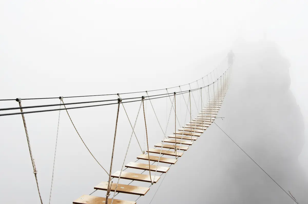 Suspension bridge disappearing into fog reflecting uncertainty and growth in depth oriented therapy annapolis