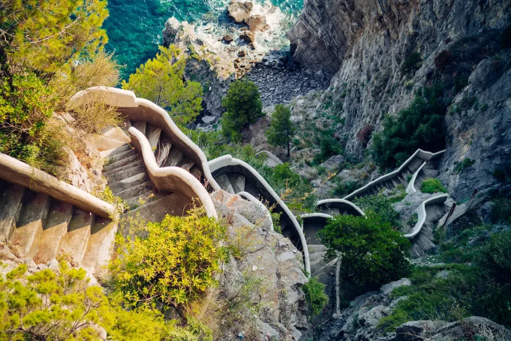 Winding cliffside staircase above the ocean, symbolizing life transitions, courage, and steady progress through challenges and healing
