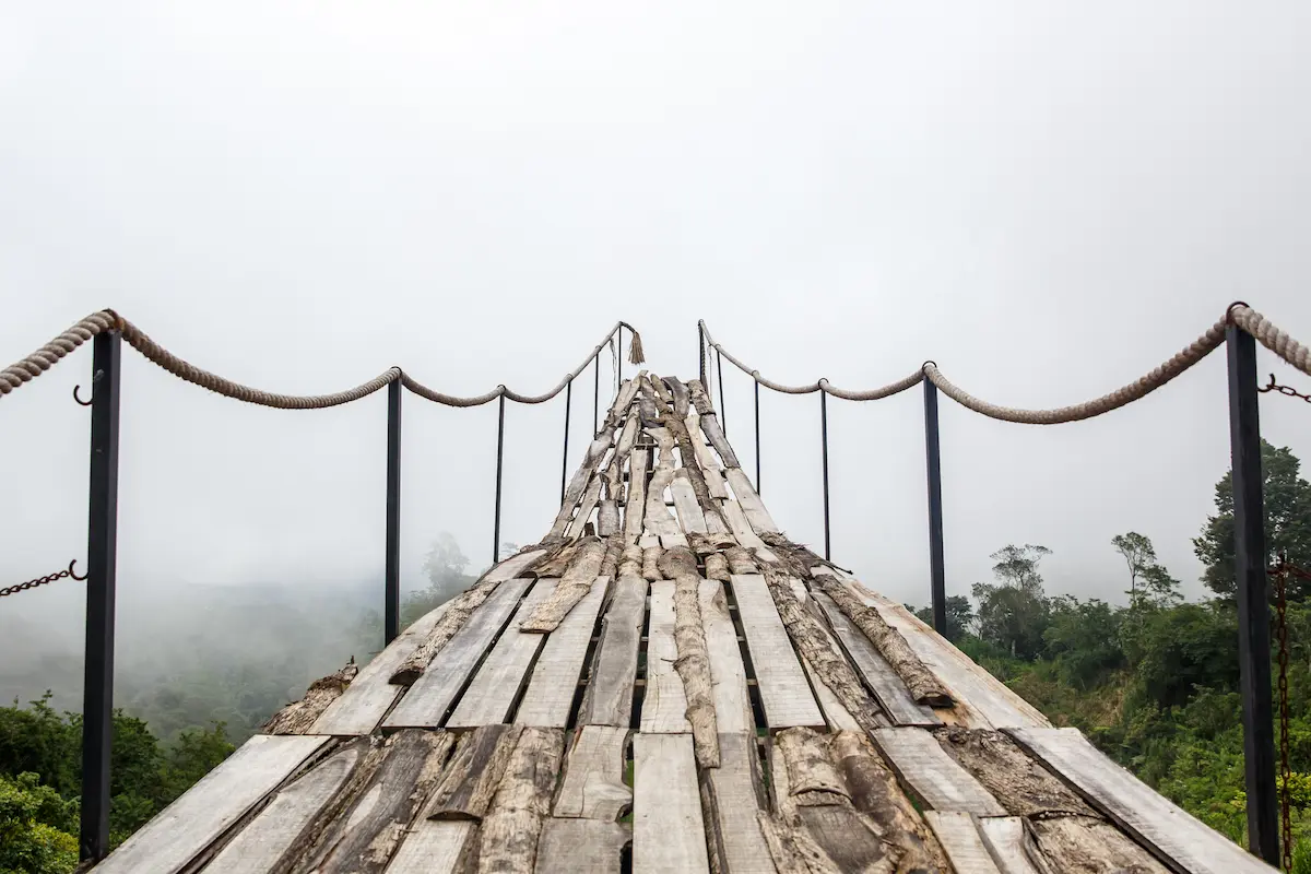 Worn wooden suspension bridge fading into mist reflecting uncertainty and growth in depth oriented therapy annapolis